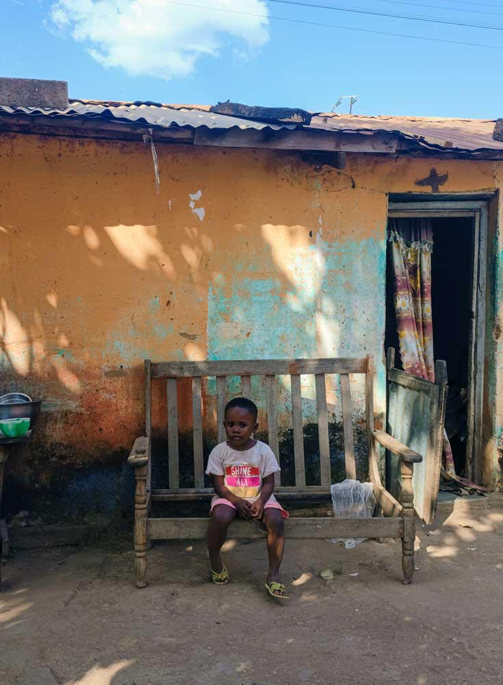 Kind sitzt auf kaputter Bank