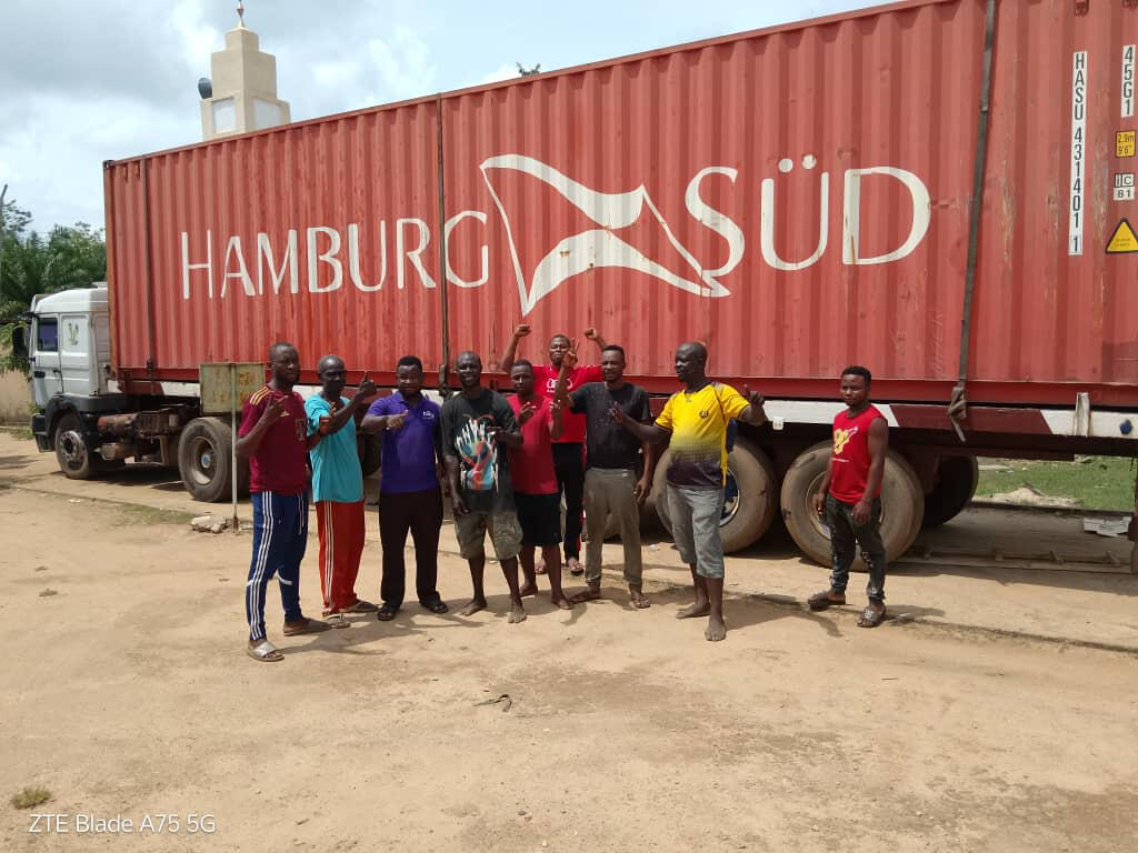 Einige Togolesen vor dem aus Freiburg gepackten Seecontainer, die sich freuen.